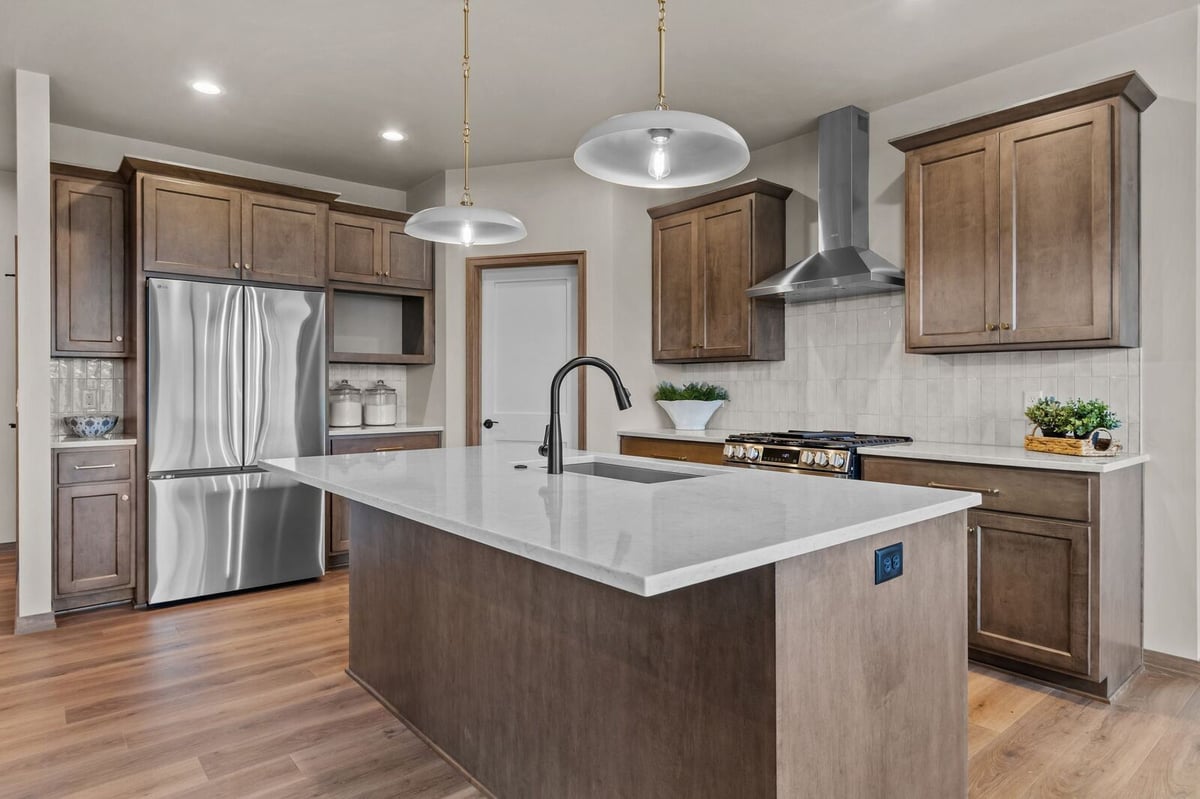 Bright Northern Wisconsin kitchen with quartz island, stainless appliances, and custom cabinetry
