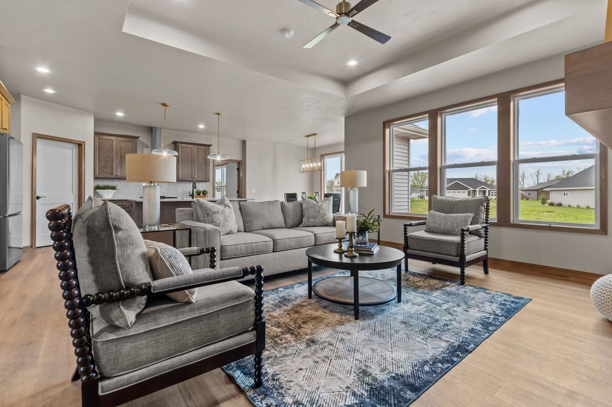 Bright Northern Wisconsin living room with large windows, tray ceiling, and modern furnishings