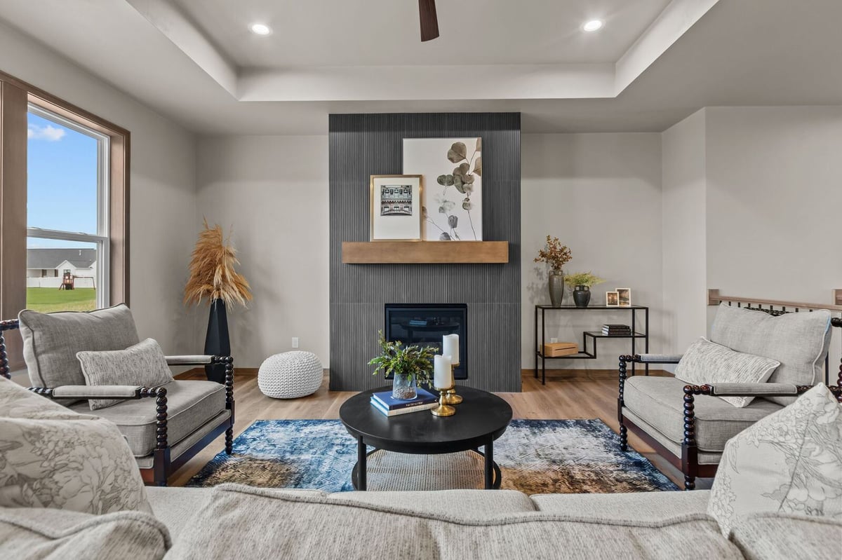 Cozy Northern Wisconsin living room with tray ceiling, fireplace, and modern seating