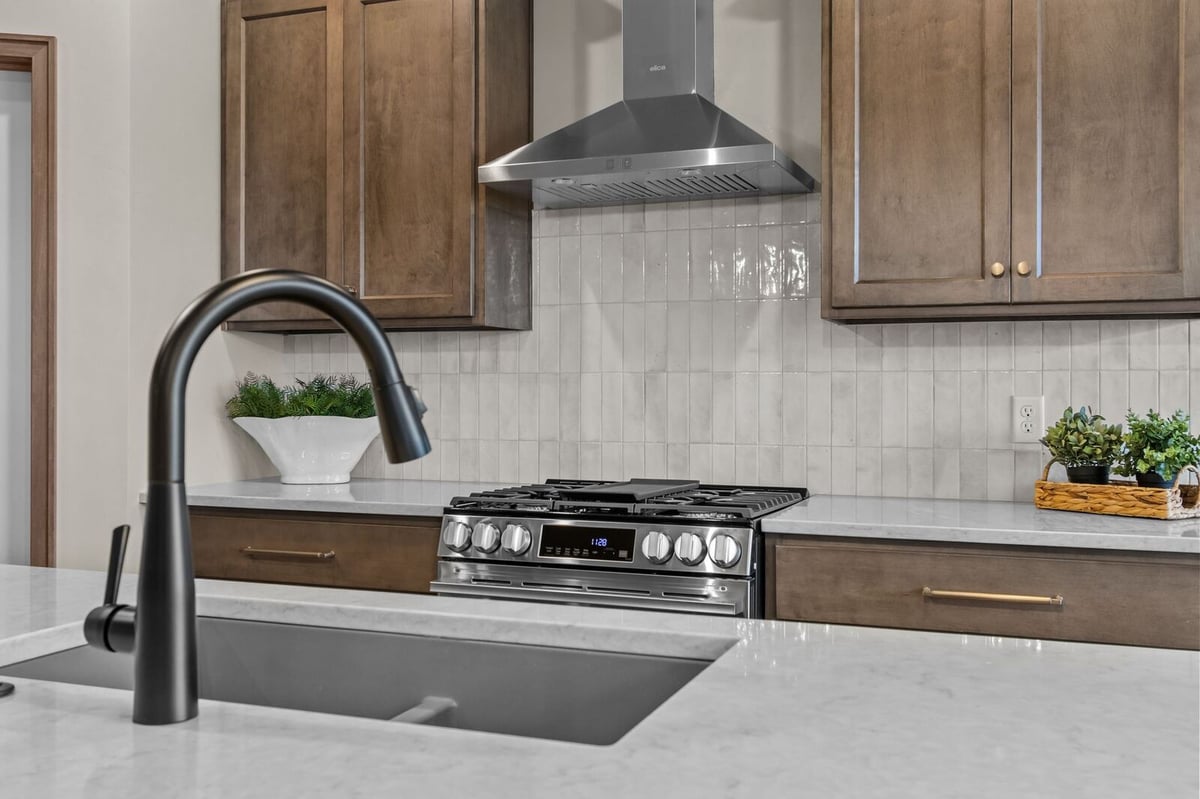 Modern gas range and tiled backsplash in a stylish Northern Wisconsin kitchen