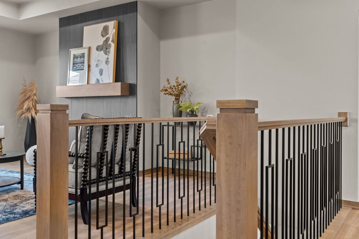 Modern staircase railing detail beside fireplace in a Northern Wisconsin open-concept home