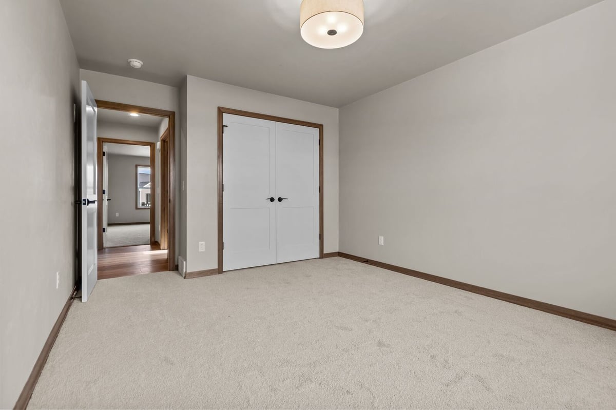 Neutral bedroom with double closet doors and soft lighting in Northern Wisconsin