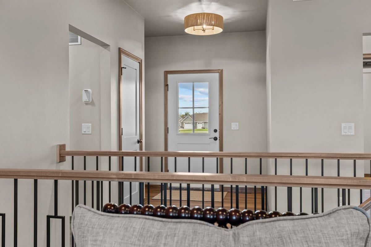 Open stair landing with modern railing and entryway in a Northern Wisconsin home
