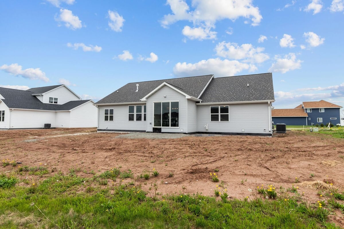 Rear exterior with large windows and backyard space at a new home in Northern Wisconsin