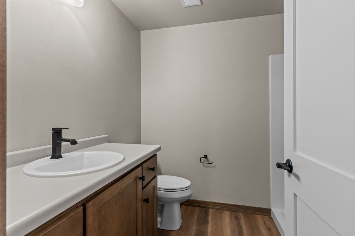 Simple bathroom with wood vanity and black fixtures in a Northern Wisconsin home