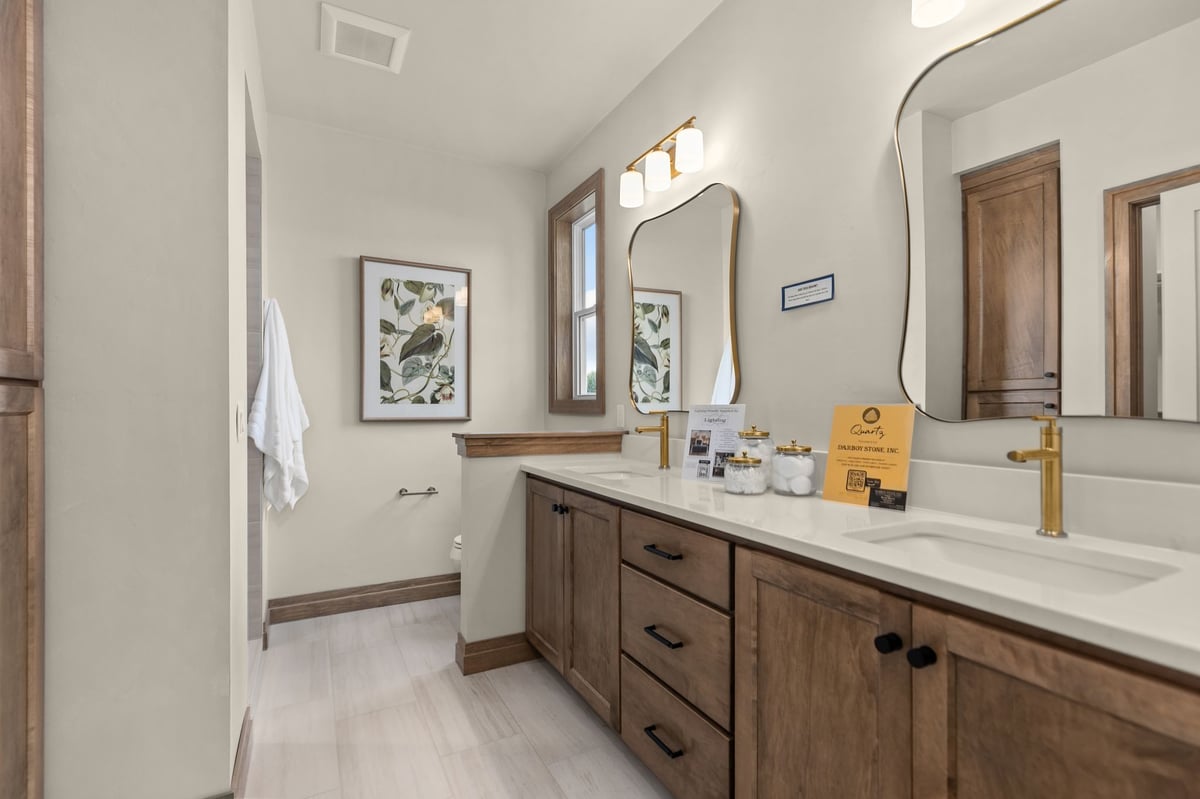 Bathroom with double vanity, wood cabinetry and brass fixtures in a Northeast Wisconsin home