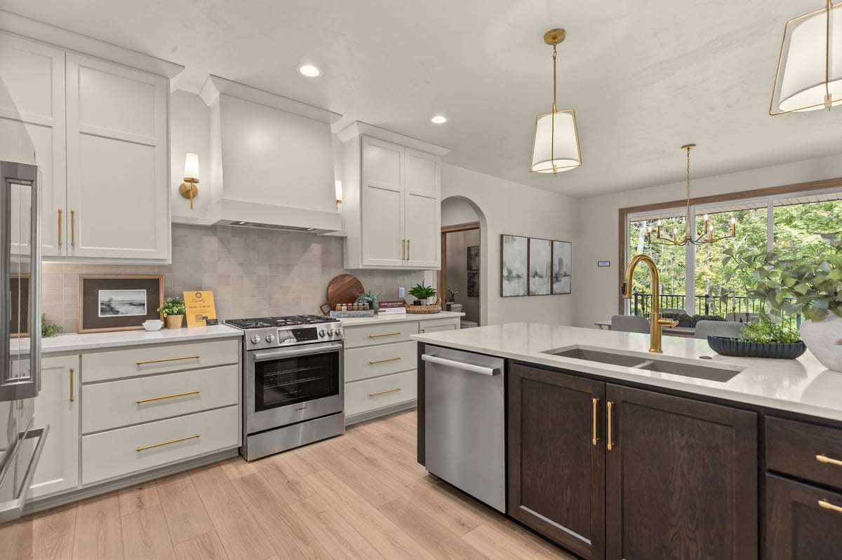 Bright kitchen with white cabinetry, dark island, brass fixtures and stainless appliances in Northeast Wisconsin