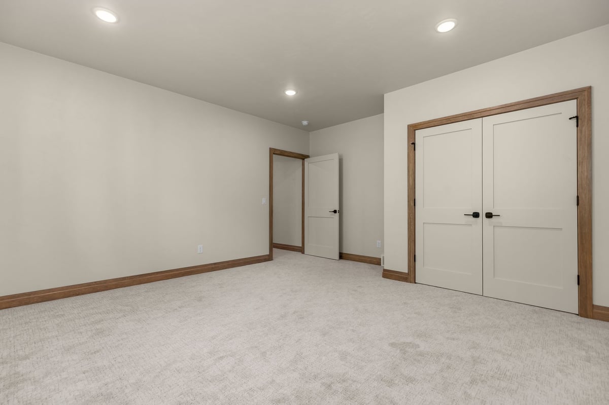 Carpeted bedroom with double closet doors and recessed lighting in a Northeast Wisconsin home