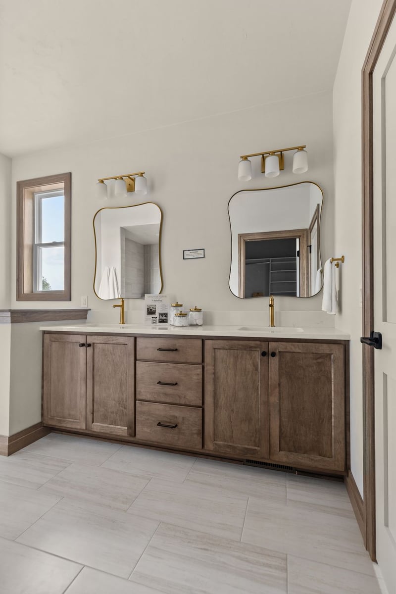 Double vanity with wood cabinetry, brass fixtures and dual mirrors in a Northeast Wisconsin home
