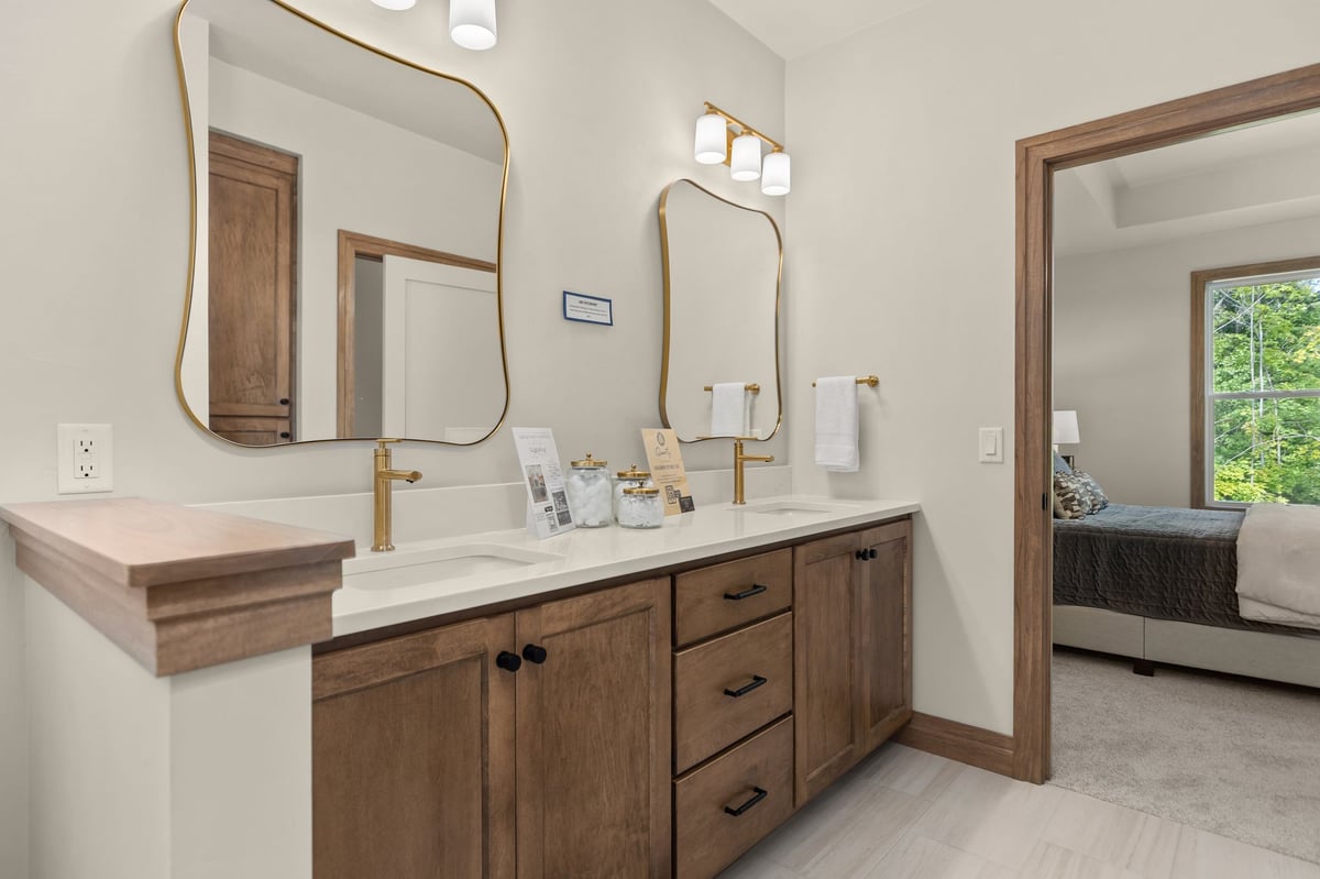 Double vanity with wood cabinetry, white countertop and brass fixtures in a Northeast Wisconsin home