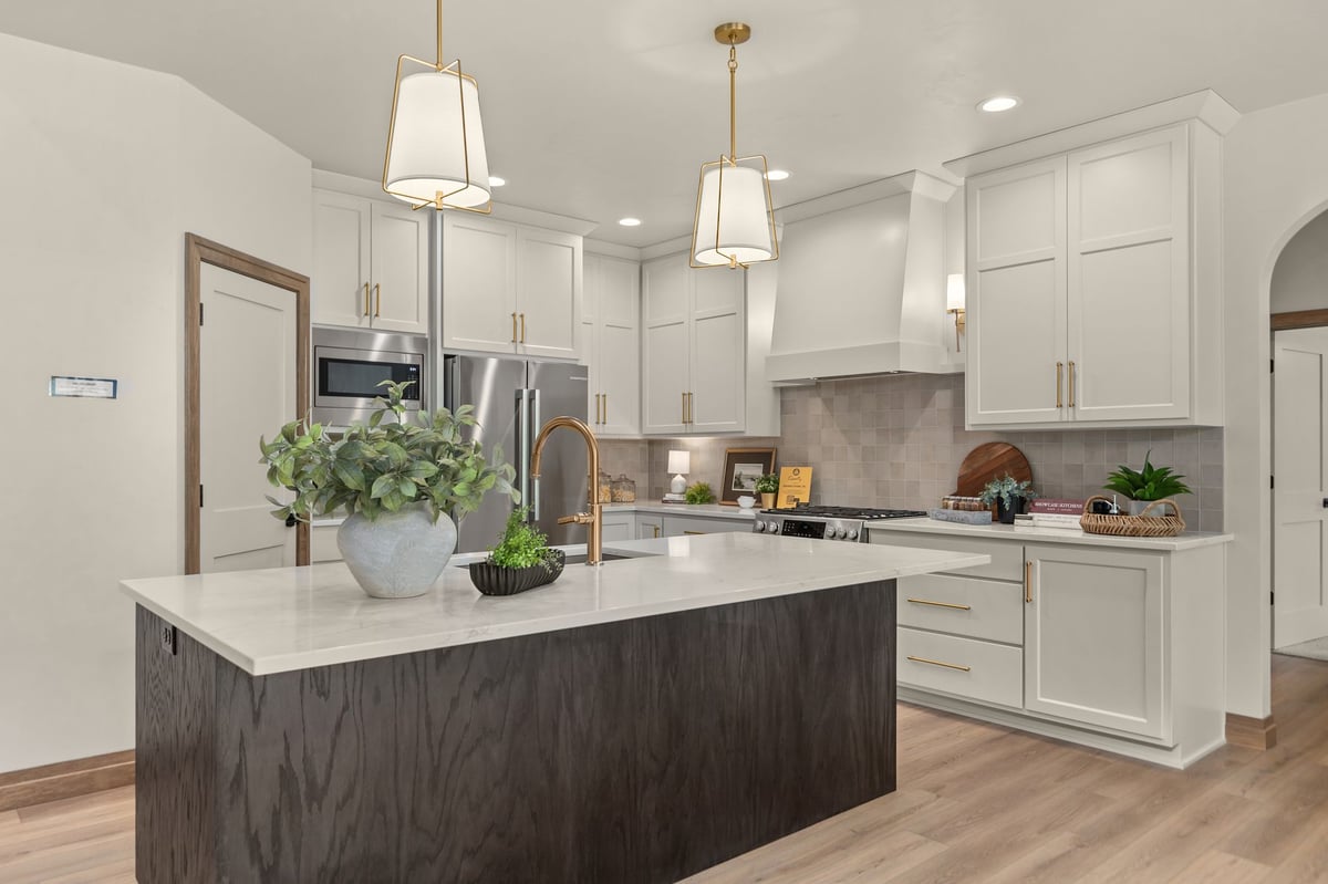 Kitchen with large dark wood island, white cabinets and brass pendant lights in Northeast Wisconsin