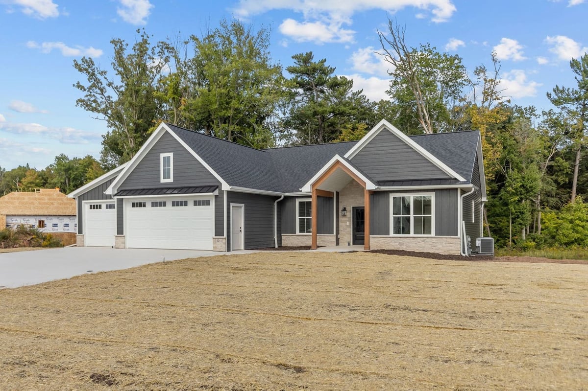 Northeast Wisconsin home with dark gray exterior, three-car garage and covered front entry