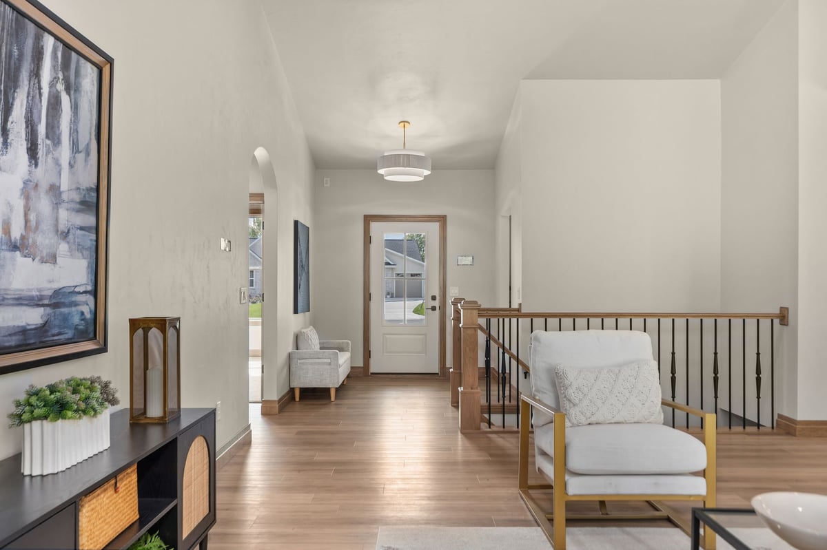 Open hallway with wood flooring, stair railing and modern accents in a Northeast Wisconsin home