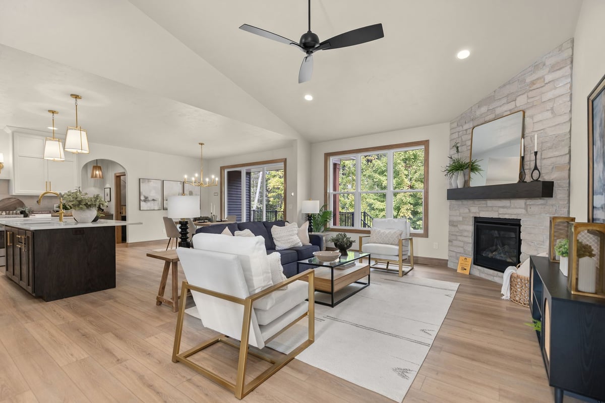 Open-concept Northeast Wisconsin living room with stone fireplace, vaulted ceiling and adjacent kitchen and dining area