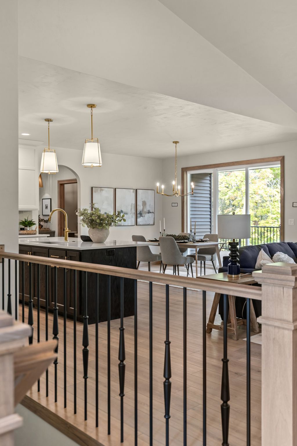 Open-concept kitchen, dining and living area with dark island and wood accents in a Northeast Wisconsin home