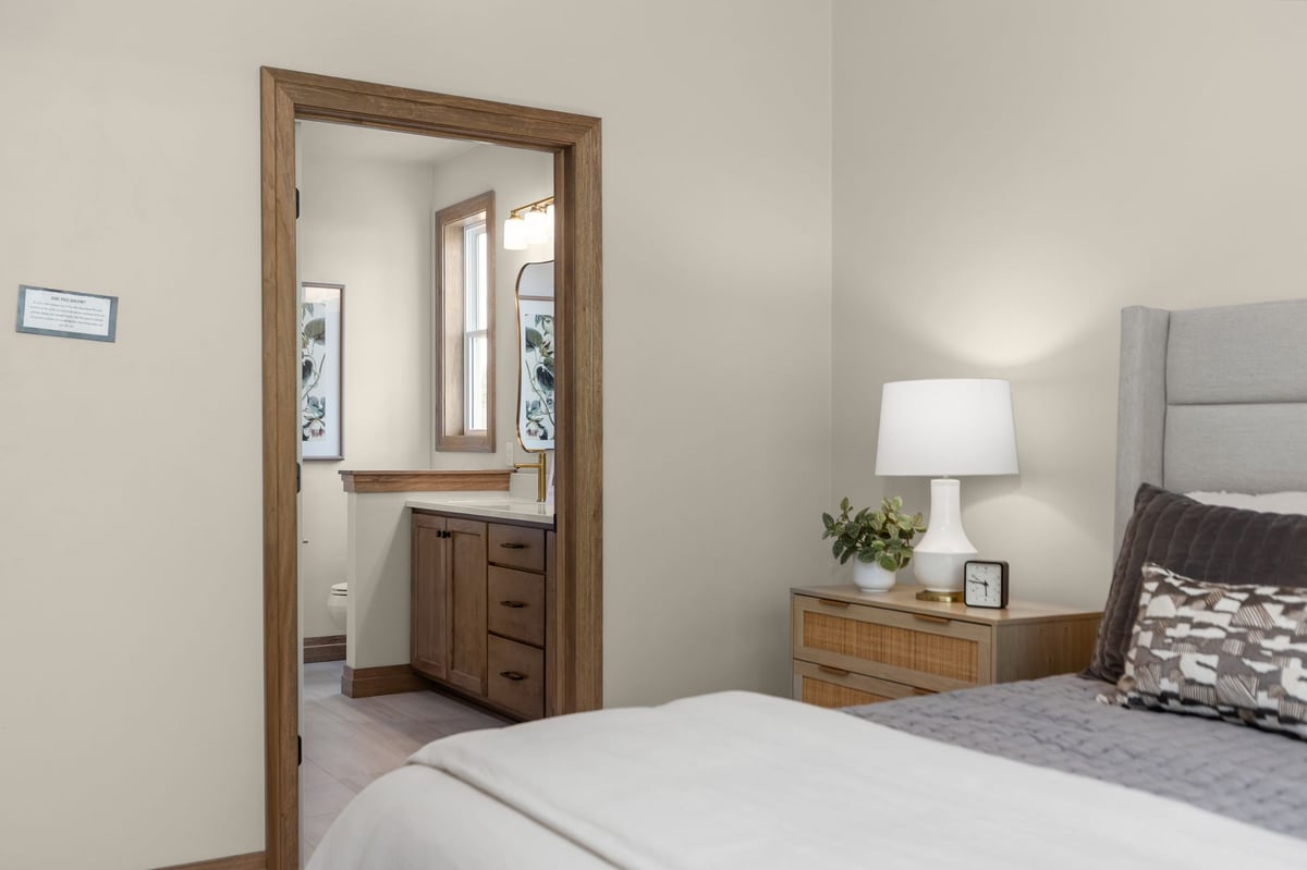 Primary bedroom with wood-trimmed doorway leading to an ensuite bathroom in a Northeast Wisconsin home