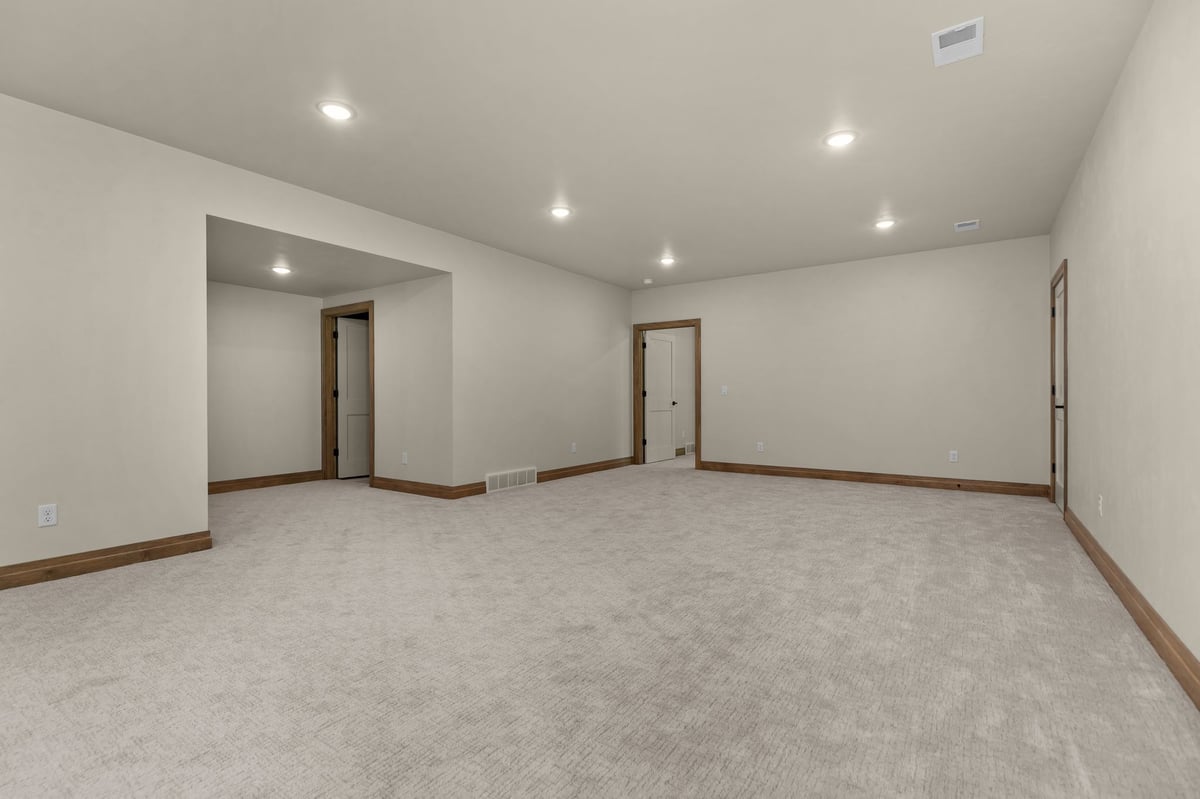 Spacious carpeted lower-level living area with recessed lighting in a Northeast Wisconsin home