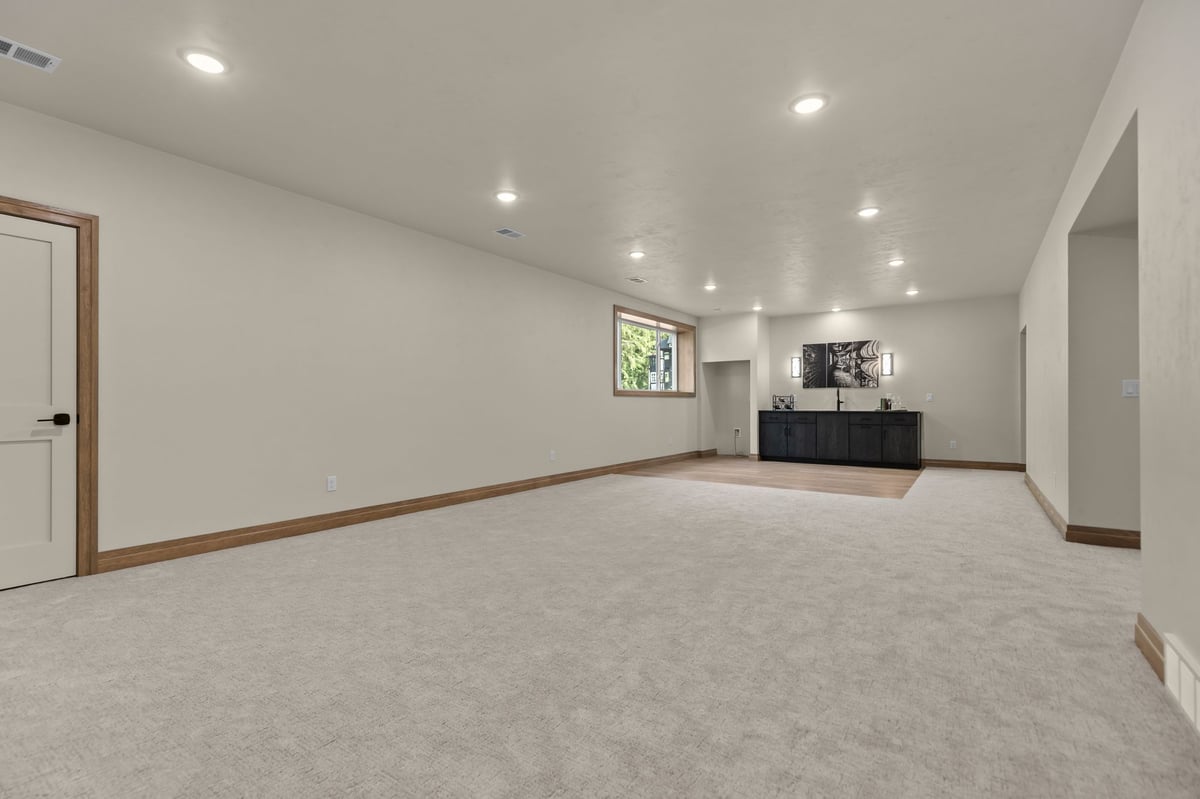 Spacious finished basement with carpet, recessed lighting and wet bar area in a Northeast Wisconsin home