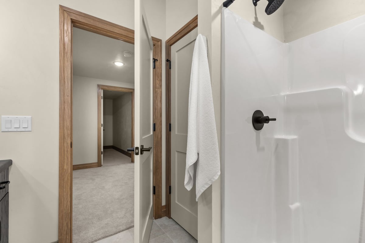 Tub and shower with black fixtures and wood-trimmed doorway in a Northeast Wisconsin home