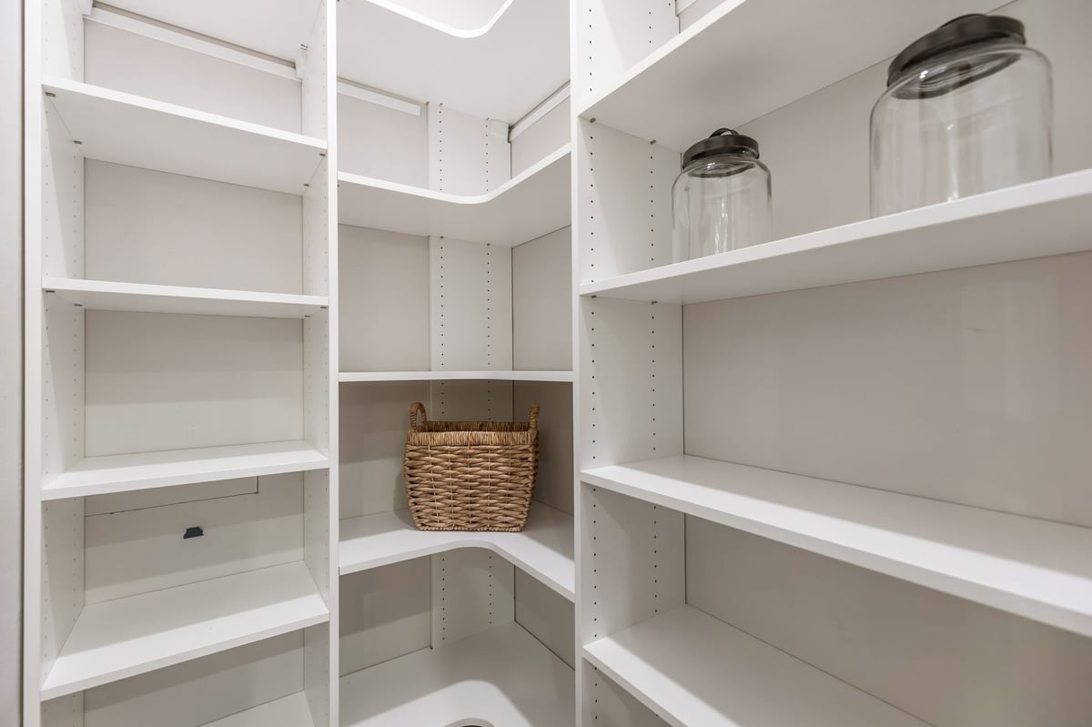 Walk-in pantry with adjustable white shelving and corner storage in a Northeast Wisconsin home