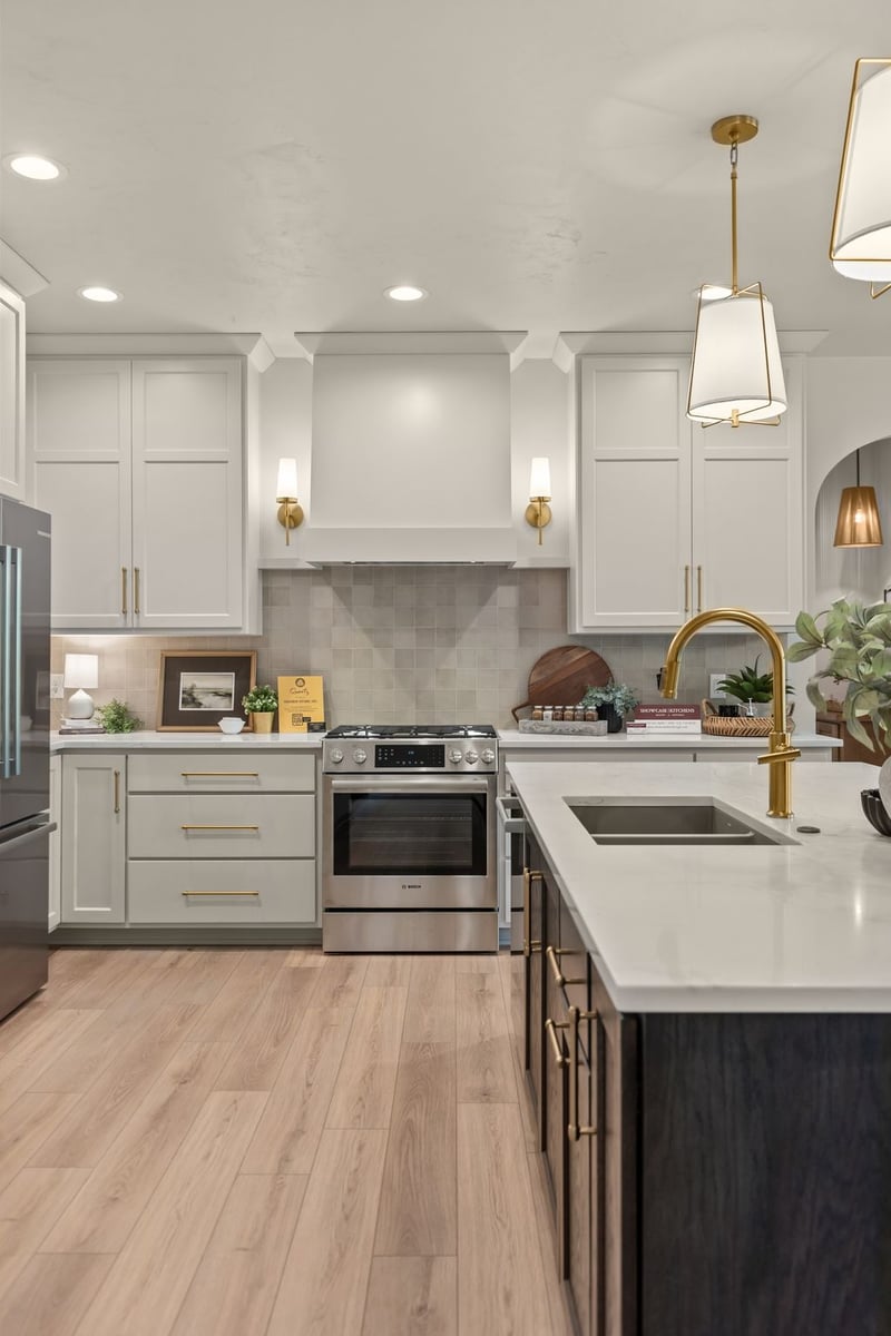 White kitchen with dark island, brass fixtures and stainless appliances in a Northeast Wisconsin home
