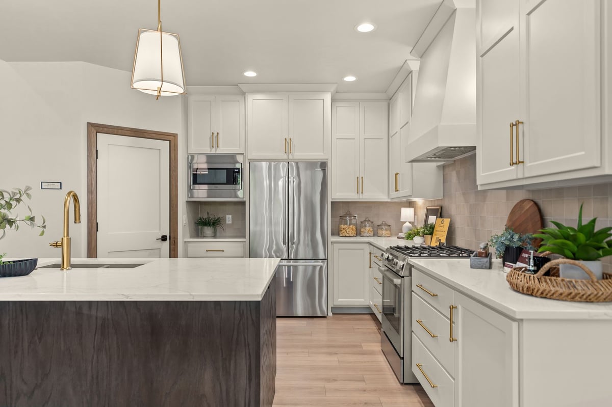 White kitchen with dark wood island, quartz countertops and stainless appliances in Northeast Wisconsin