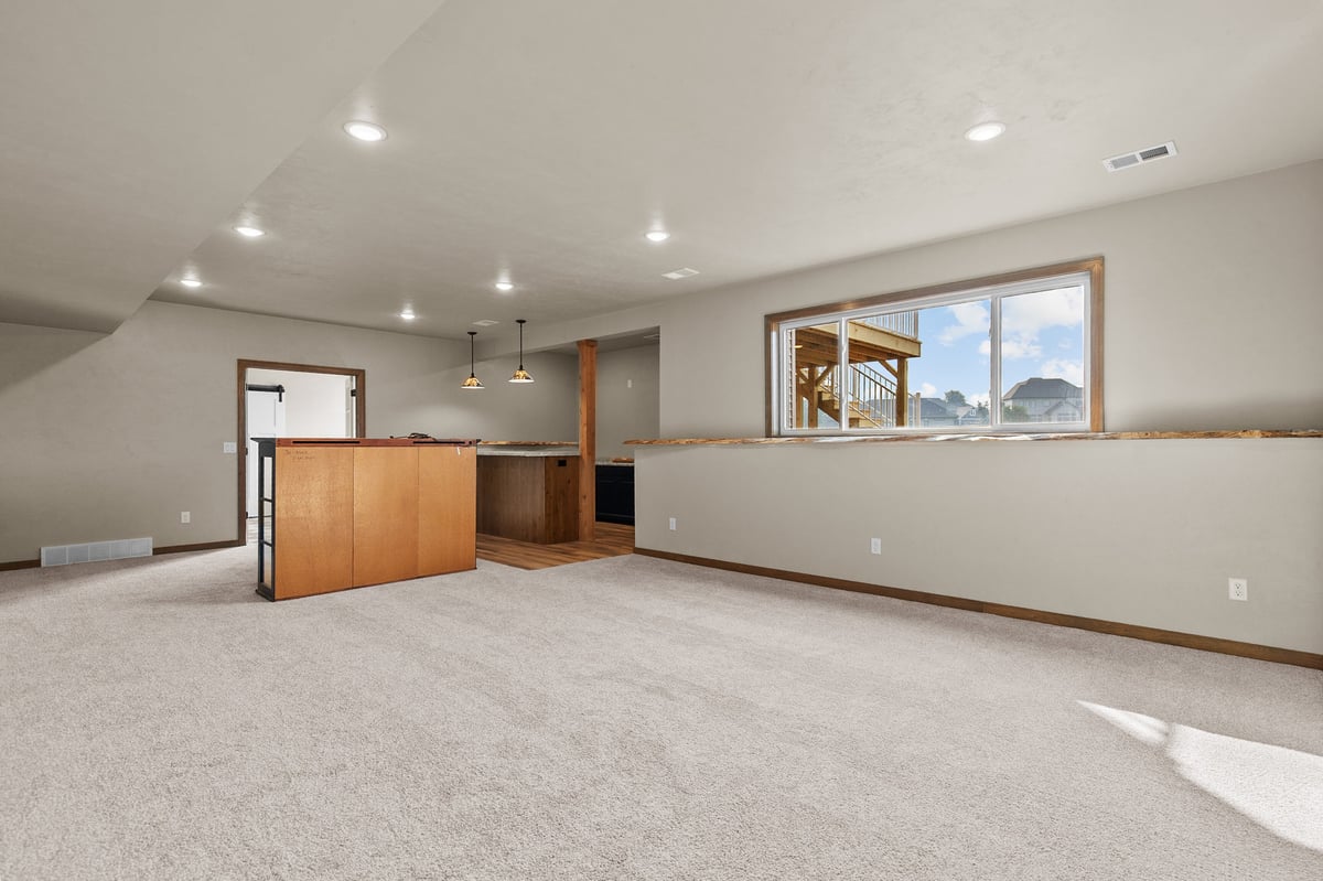 Appleton, WI finished basement with carpet, open layout, bar area, recessed lighting, and large window for natural light