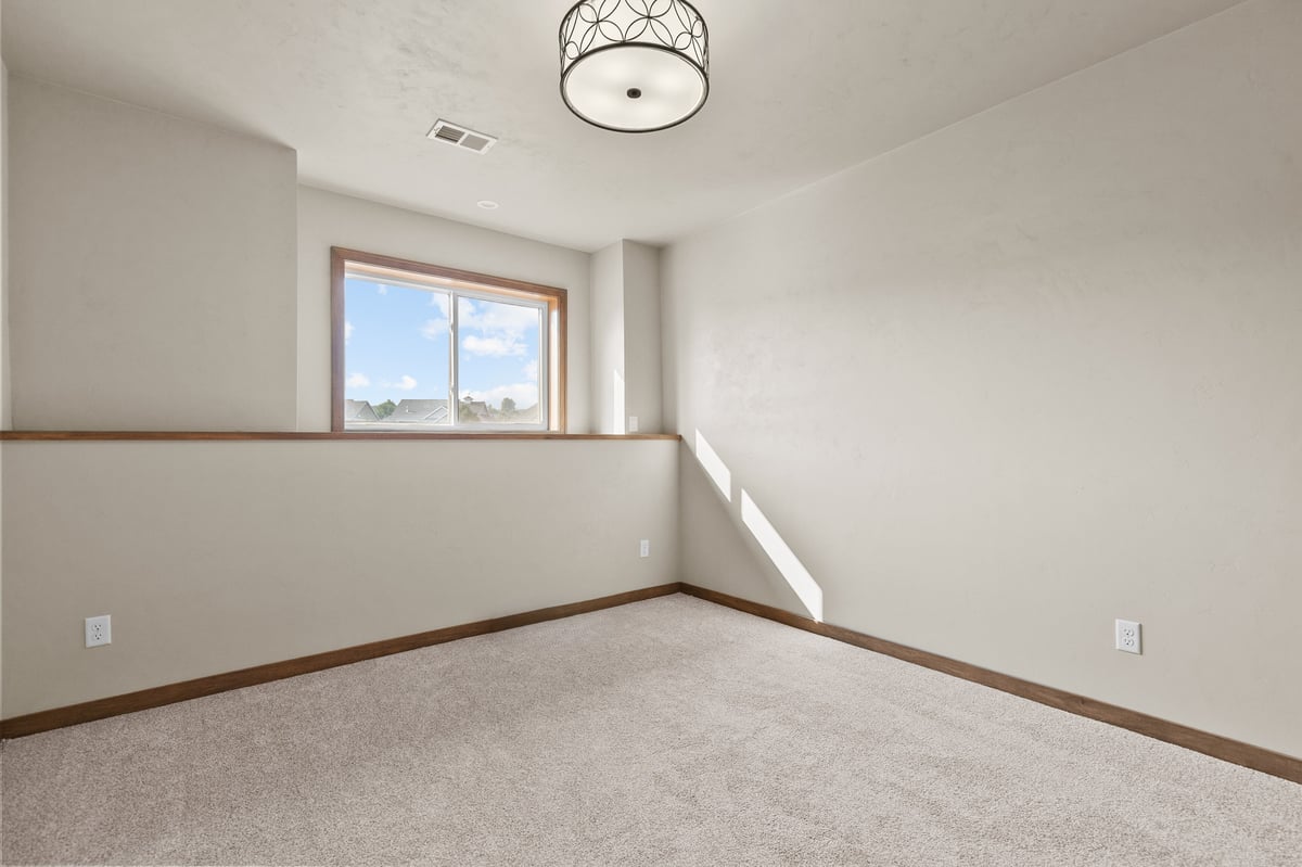 Appleton, WI bedroom with carpet, modern ceiling light, partial wall detail, and window bringing in natural light