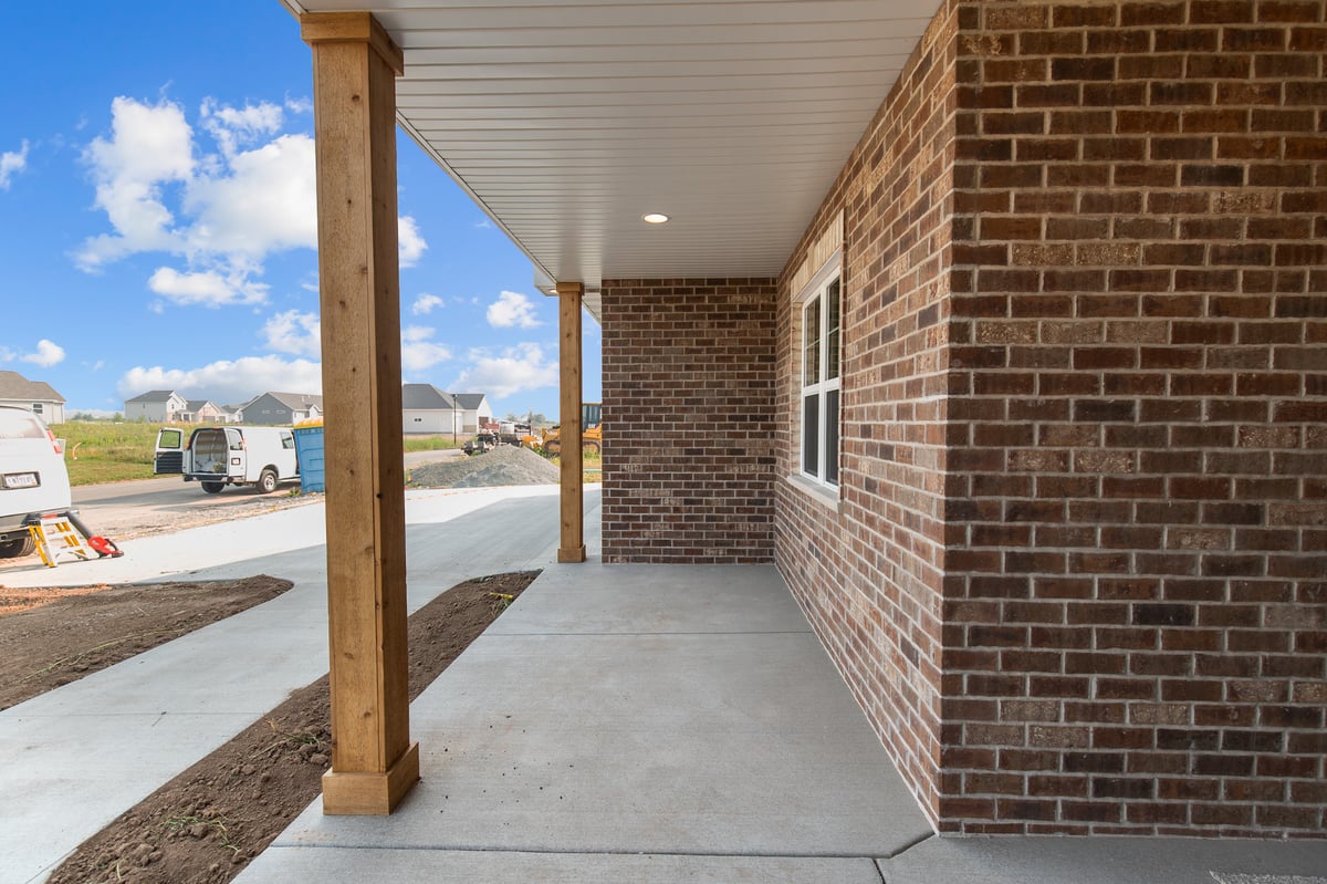 Appleton, WI covered front porch with brick exterior, wood posts, concrete walkway, and neighborhood views