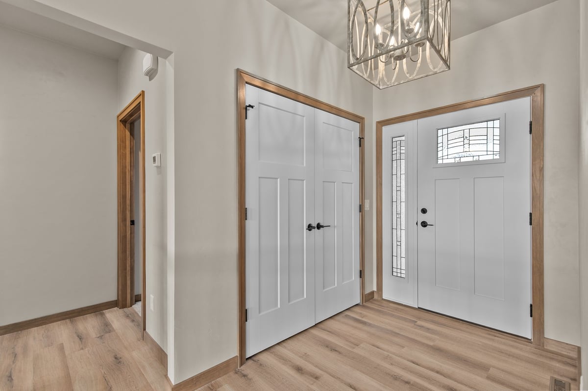 Appleton, WI entryway with double closet doors, front door with glass panel, wood flooring, and modern light fixture