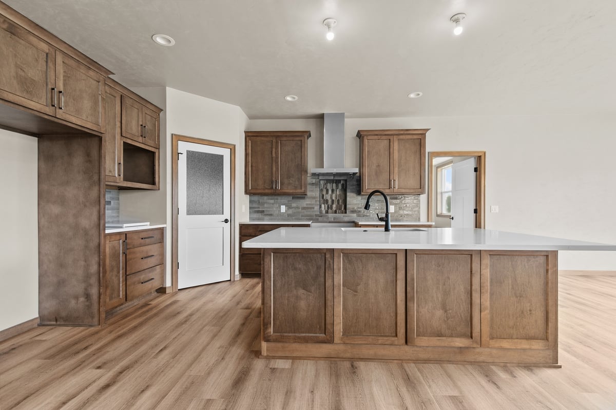 Appleton, WI kitchen with wood cabinetry, large island, white countertops, and open layout with modern finishes