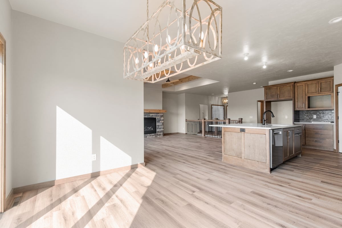 Appleton, WI open dining and kitchen area with wood floors, large island, modern chandelier, and spacious layout filled with natural light