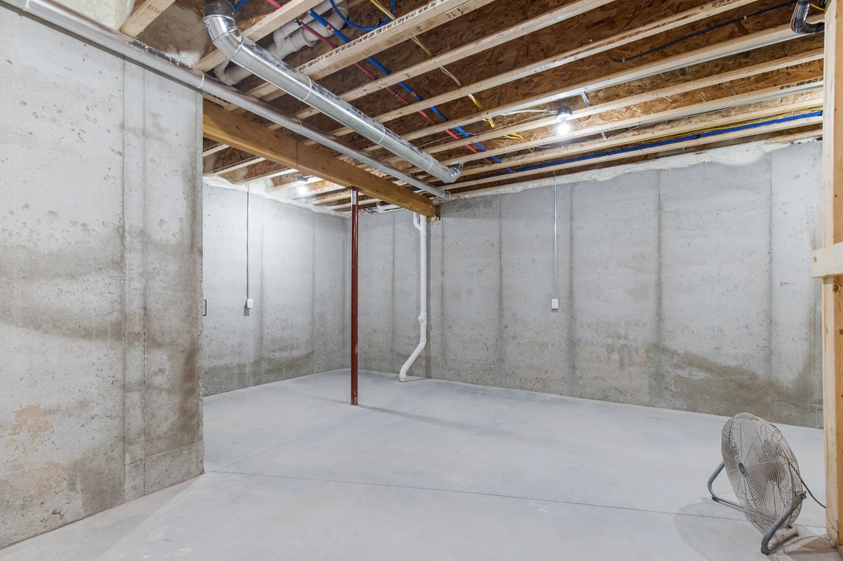 Appleton, WI unfinished basement with concrete floors, exposed ceiling beams, ductwork, and open utility space