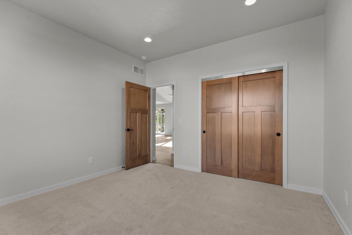 Appleton, WI bedroom with carpet, wood doors, neutral walls, and view into bright hallway
