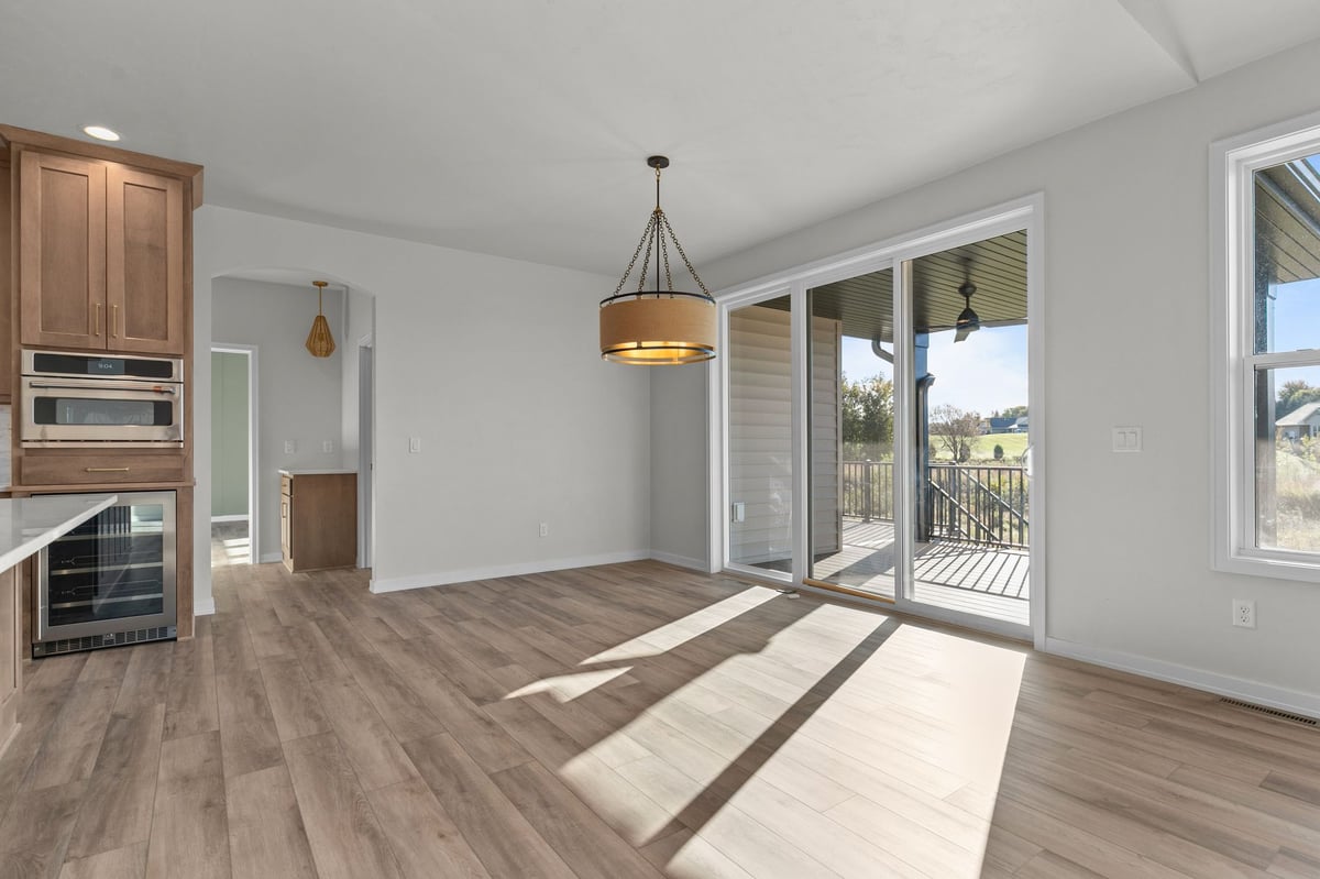 Appleton, WI dining area with sliding glass doors, wood floors, modern light fixture, and access to outdoor deck