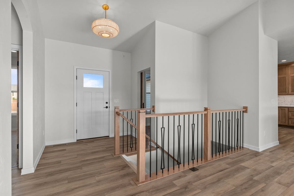 Appleton, WI entryway with staircase, wood railing, modern light fixture, and open layout