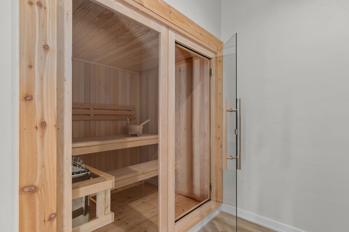 Appleton, WI home sauna with wood interior, glass door, bench seating, and spa features