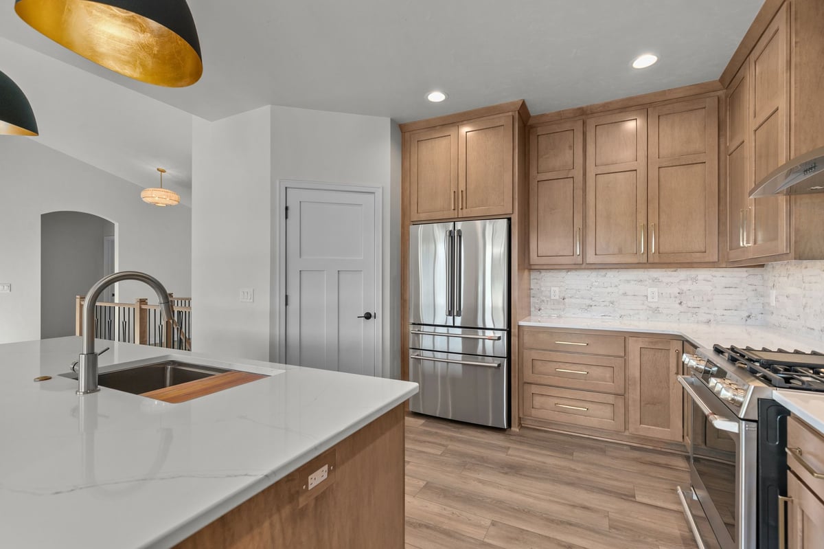 Appleton, WI modern kitchen with wood cabinetry, white countertops, stainless appliances, and recessed lighting