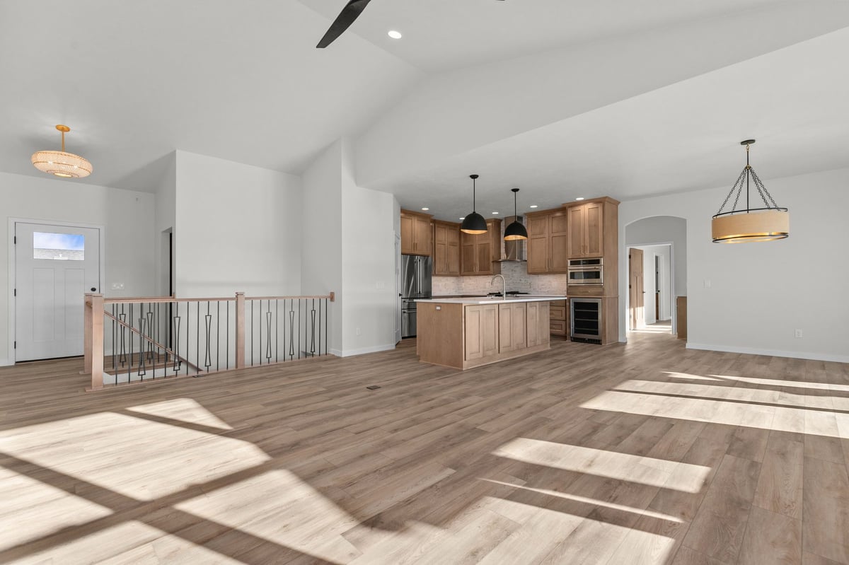 Appleton, WI open concept kitchen and living area with island, wood floors, railing, and abundant natural light