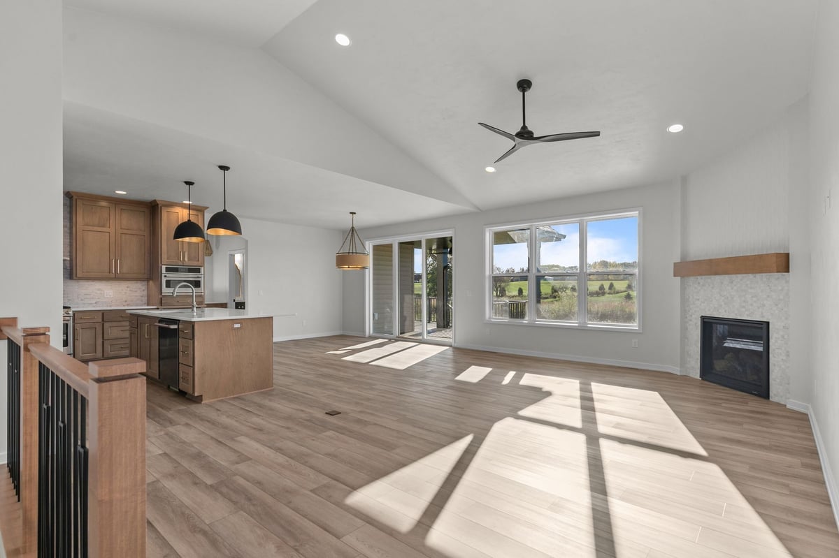 Appleton, WI open living room with kitchen, fireplace, large windows, sliding doors, and wood flooring