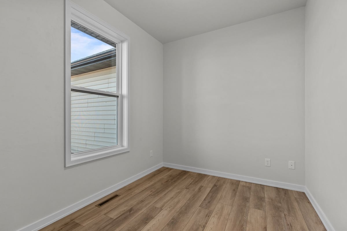 Appleton, WI small room with wood flooring, white walls, and window for natural light
