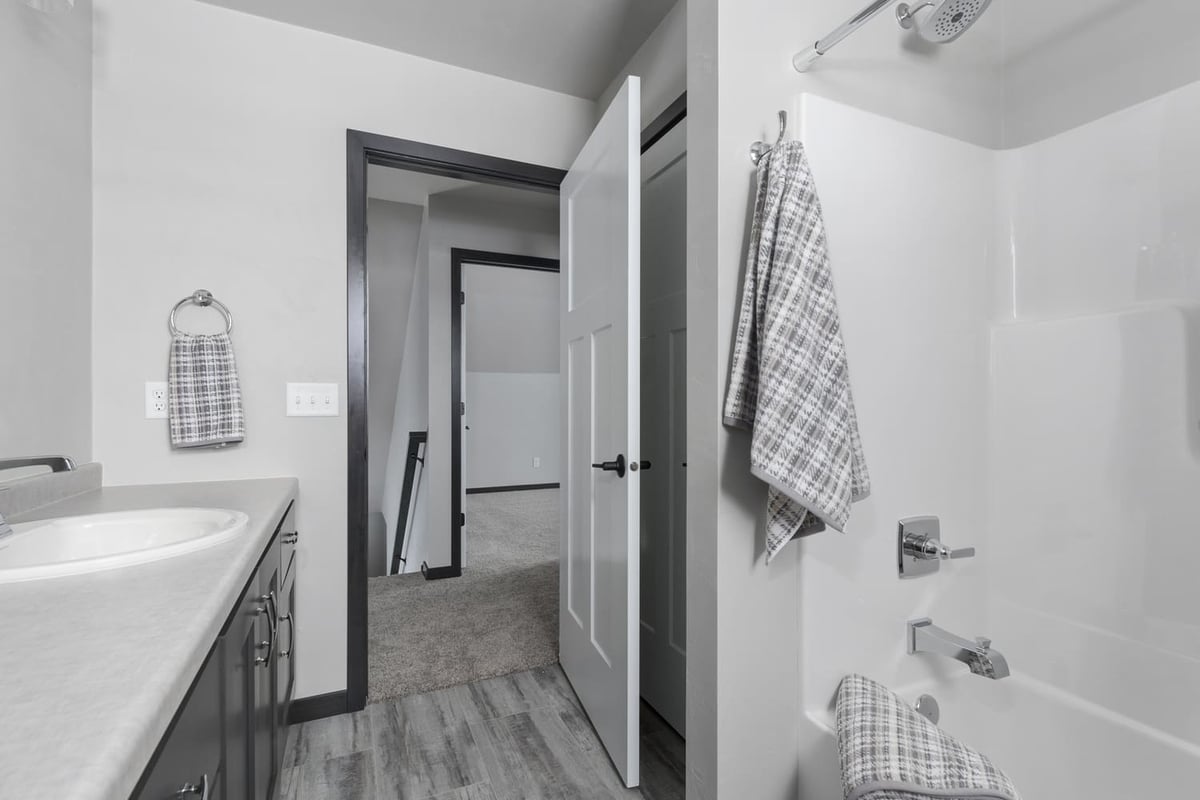 Bathroom with tub shower, single vanity, and neutral finishes in a Fox Cities home