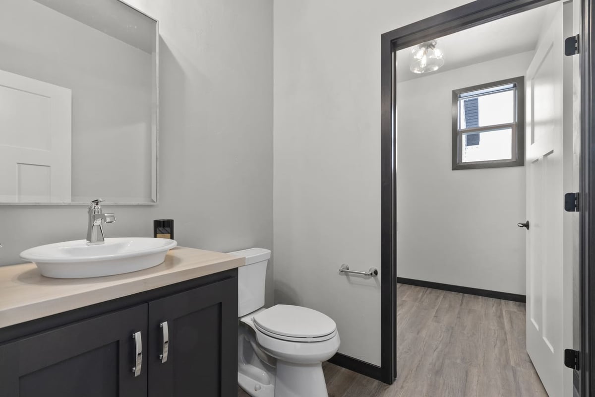 Half bath with single vanity, toilet, and vinyl flooring in a Fox Cities home