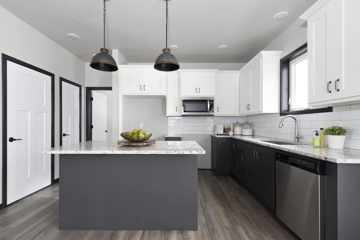 Kitchen with large island, granite counters, stainless appliances, and pendant lights in the Fox Cities