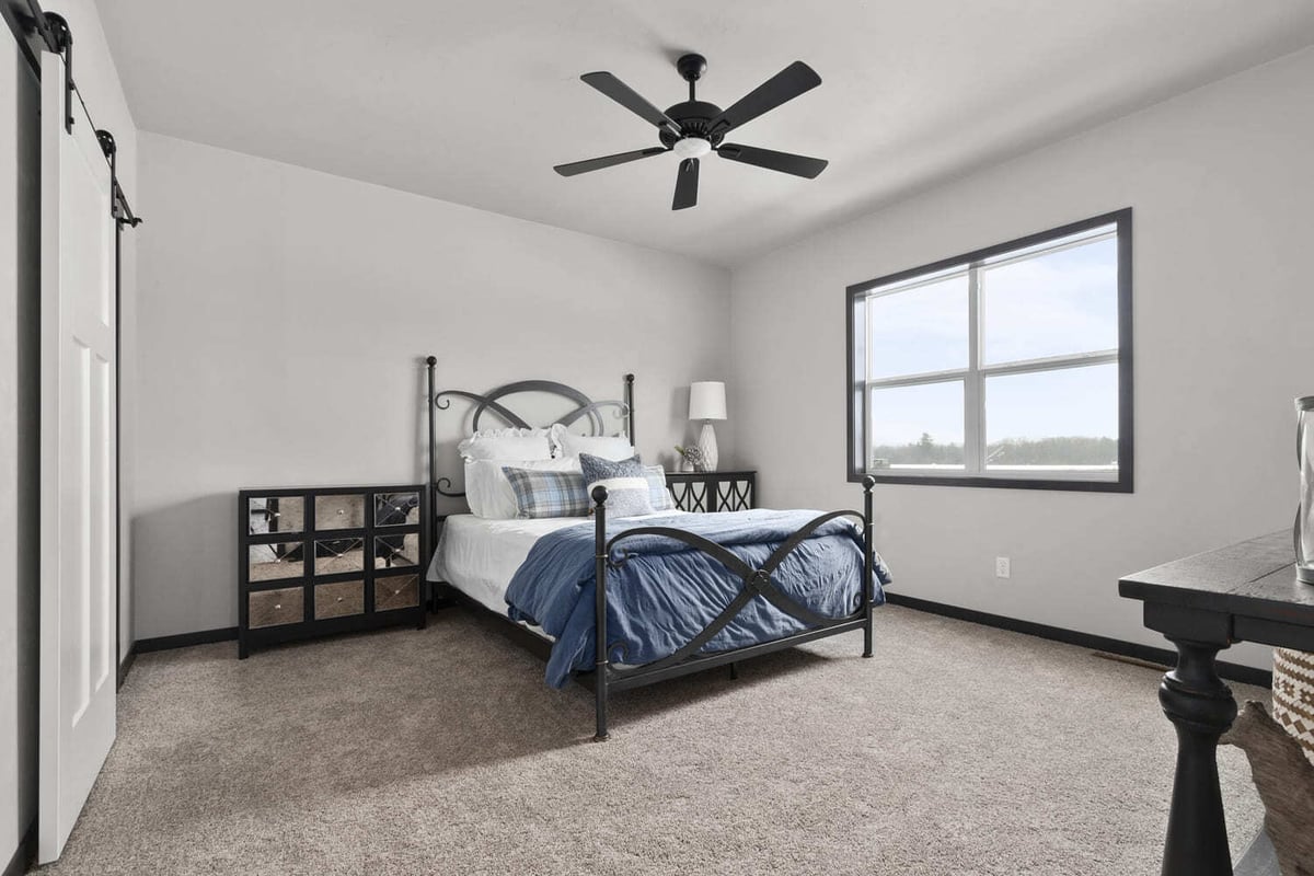 Modern bedroom featuring a black metal bed frame and neutral tones in the Fox Cities