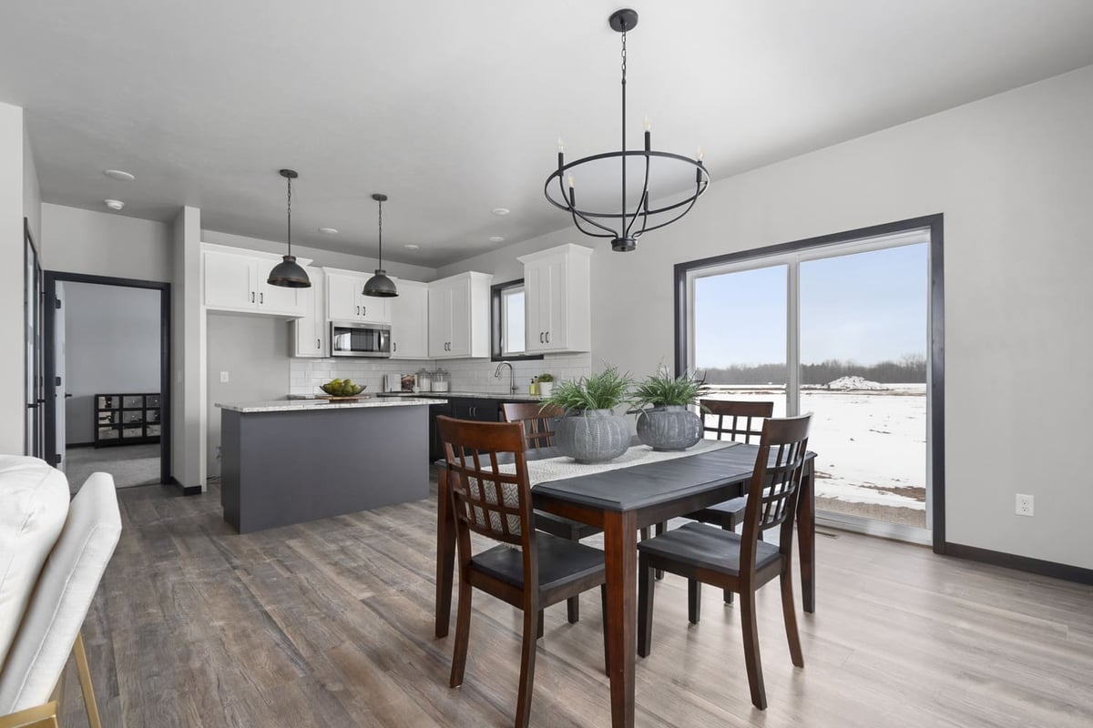 Open dining and kitchen space with island, pendant lighting, and large windows in a Fox Cities home