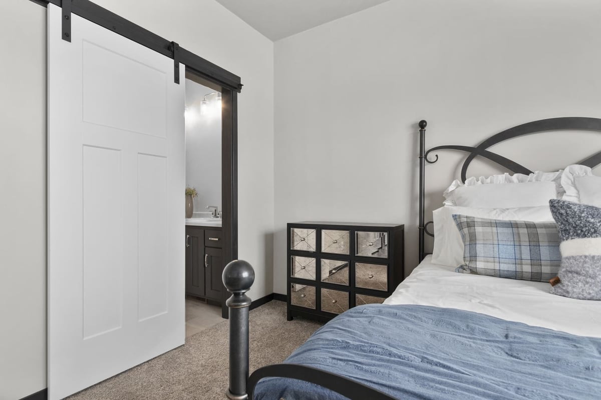 Primary bedroom with barn door to ensuite bath, neutral tones, and carpeted floor in the Fox Cities