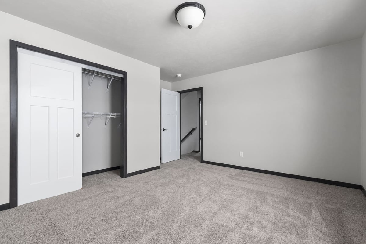 Unfurnished carpeted bedroom with open closet and neutral finishes in a Fox Cities home