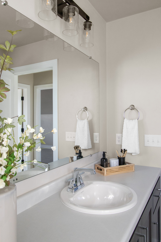 Custom bathroom design with single sink and modern fixtures in Kaukauna, WI by Midwest Design Homes
