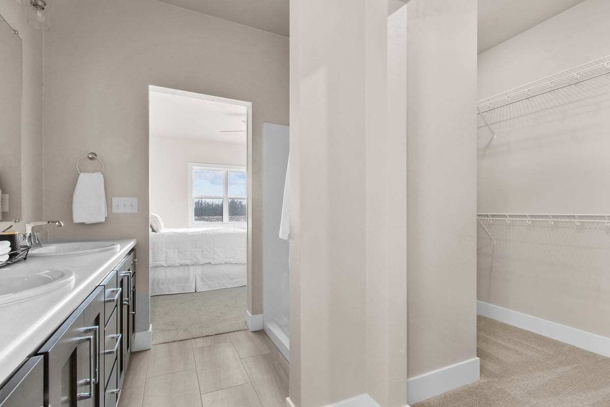 Custom home bathroom with double vanity and walk-in closet by Midwest Design Homes in Kaukauna, WI